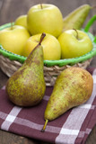 Fresh green apples and pears on a wooden table
