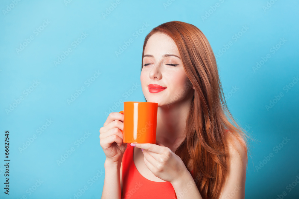 Redhead women with cup on blue background. Redhead women with cup on blue background.