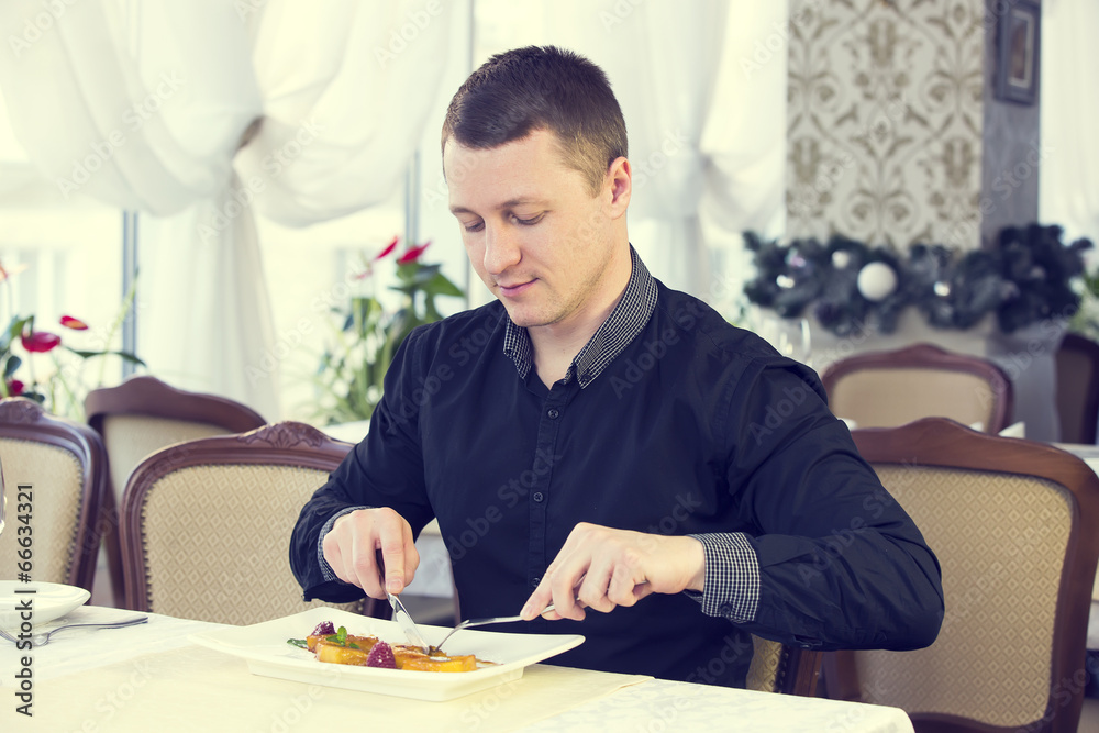 young man having dinner in a restaurant