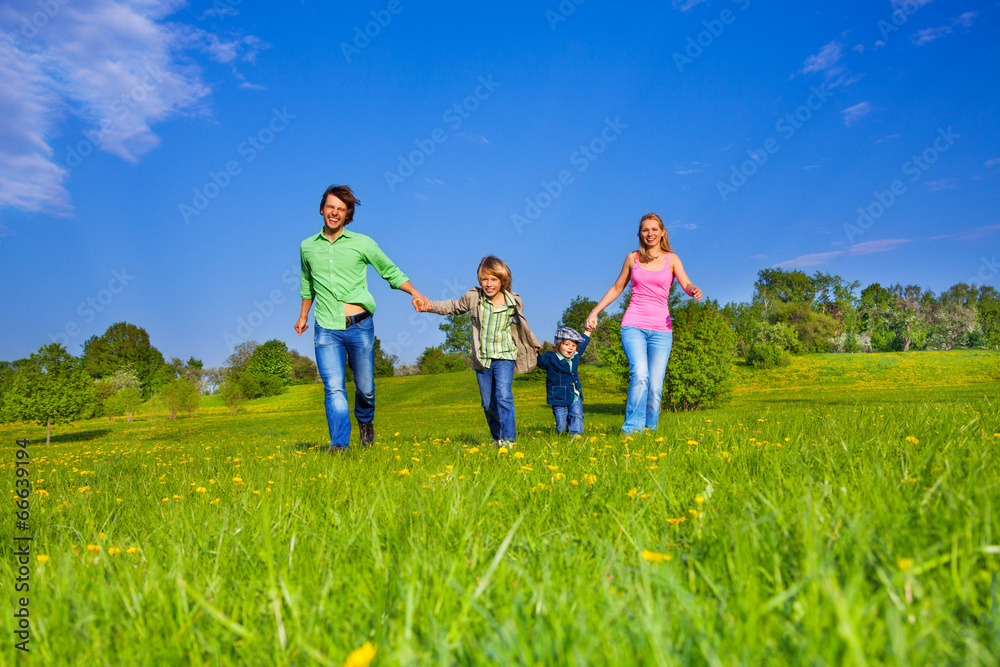 Happy parents walk with boys in park Happy parents walk with boys in park