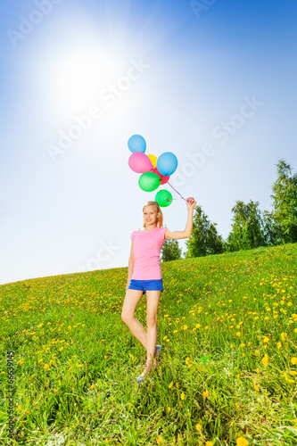 Standing girl with balloons in summer