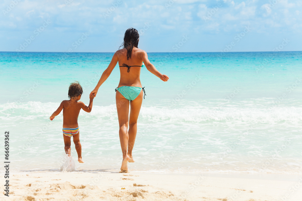 Child and woman holding hands on sea background Child and woman holding hands on sea background