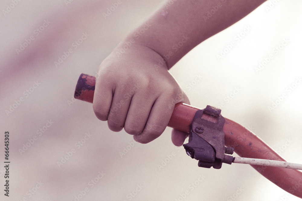 Hand's little boy and old bicycle handlebar, retro style Hand's little boy and old bicycle handlebar, retro style