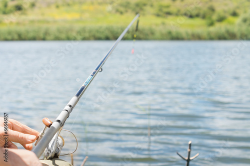 Man fishing on a lake with a spinning reel and rod