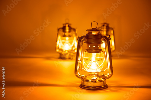 Burning three kerosene lamps background, concept light