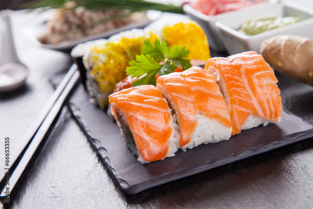 Delicious sushi pieces served on black stone Delicious sushi pieces served on black stone