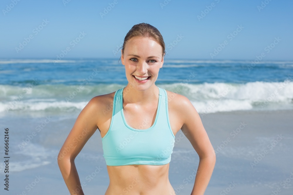 Fit woman standing on the beach with hands on hips Fit woman standing on the beach with hands on hips