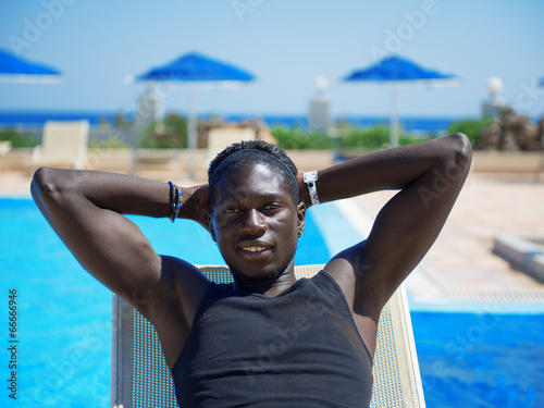 young african man relaxing on beach