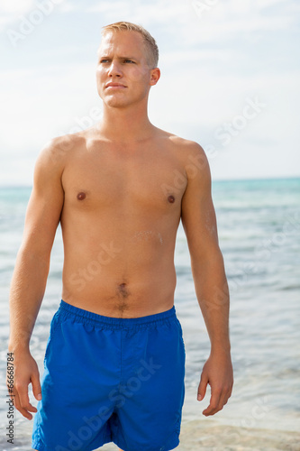 Man in blue swim shorts in the beach