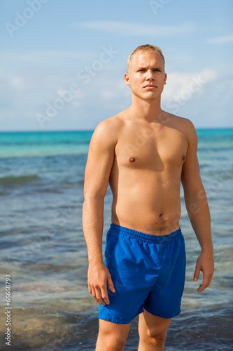 Man in blue swim shorts in the beach