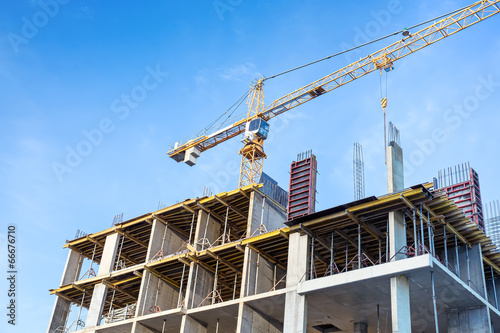 Construction site with cranes against blue sky