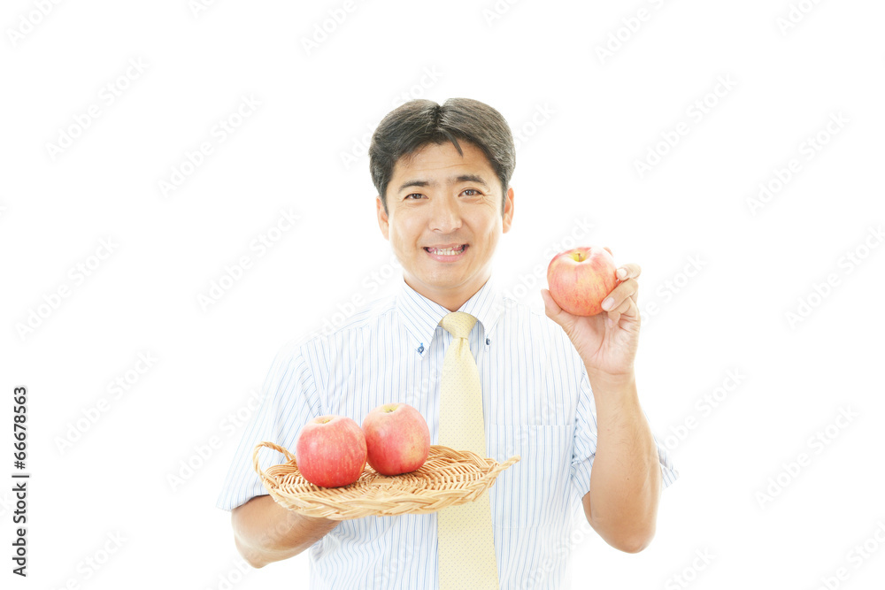 リンゴを食べる笑顔のサラリーマン