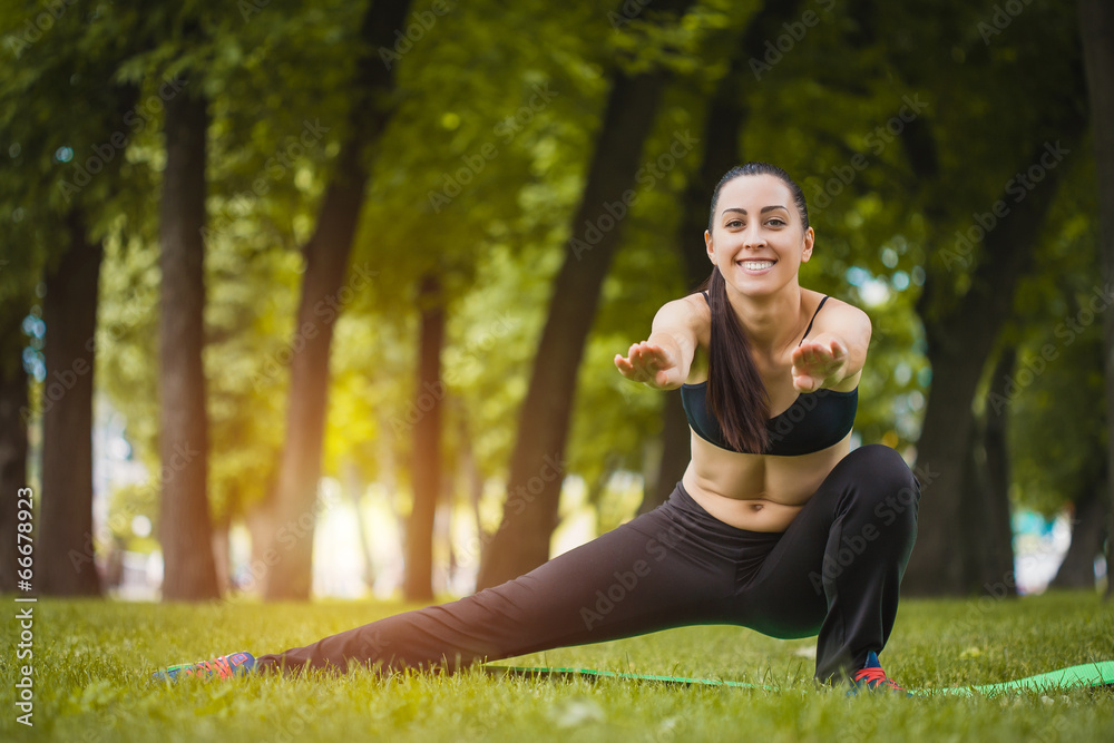 Pretty woman doing exercises in the park