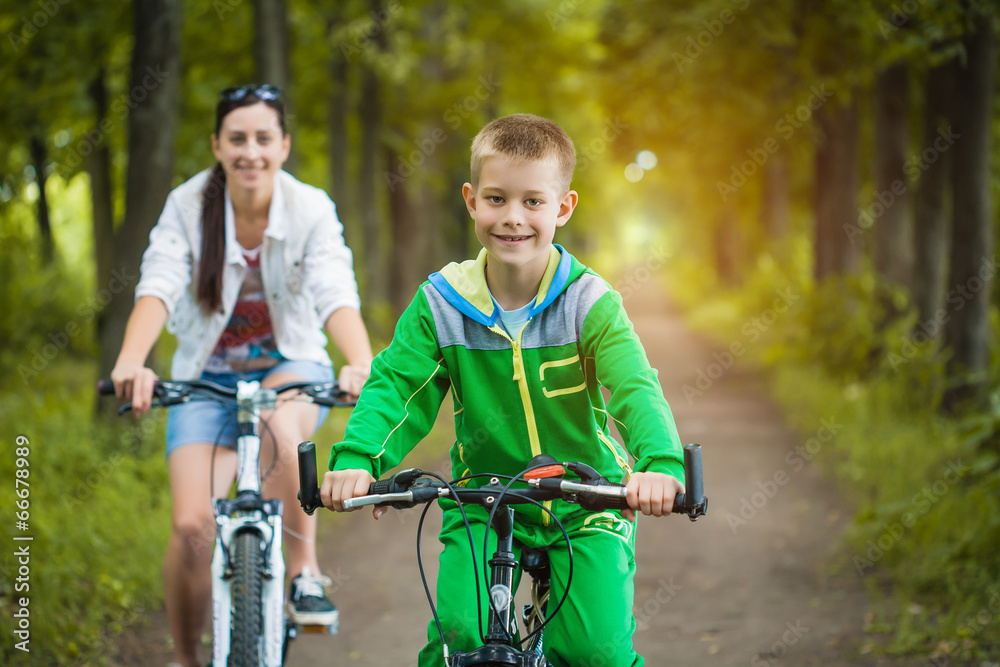 mother and son riding bicycle in the park