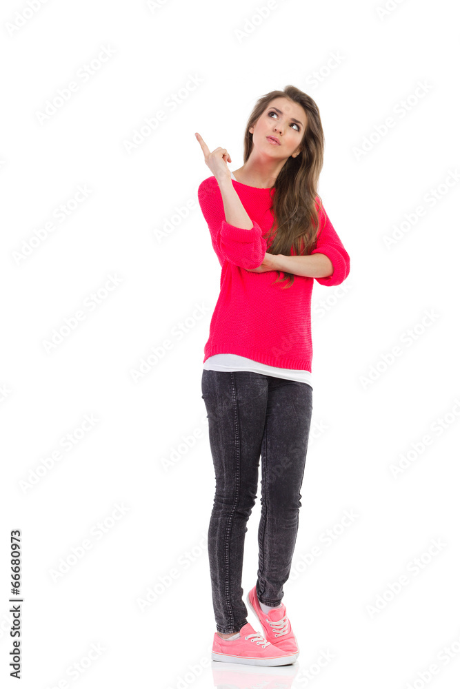 Young woman pointing up at empty space. Young woman pointing up at empty space.
