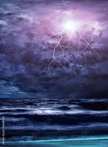 Lightning flashes across the beach from a storm