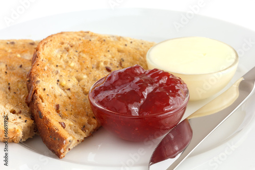 Slice of multi-seed wholegrain bread toasted with butter and jam