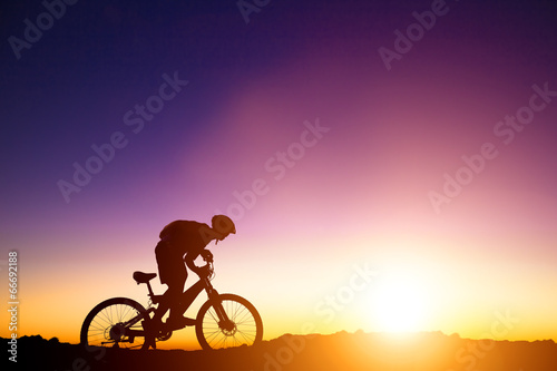 Fototapeta Naklejka Na Ścianę i Meble -  mountain bicycle rider on the hill with sunrise background