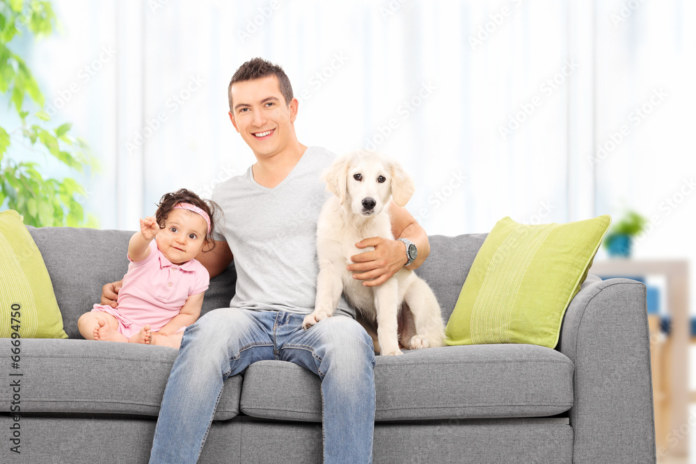 Father sitting at home with his daughter and puppy