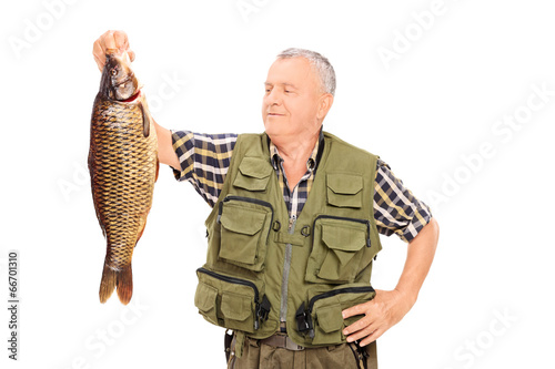 Proud mature fisherman holding a big fish