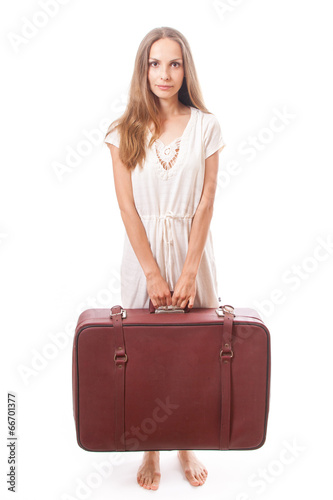 woman lifts a heavy suitcase, isolated on white