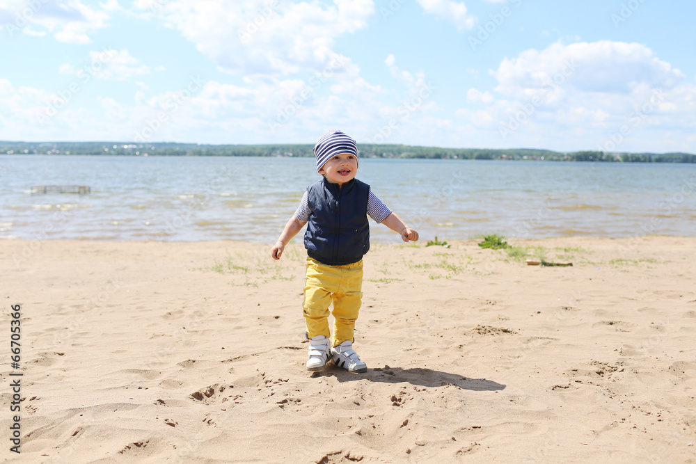 happy baby boy walking on riverside