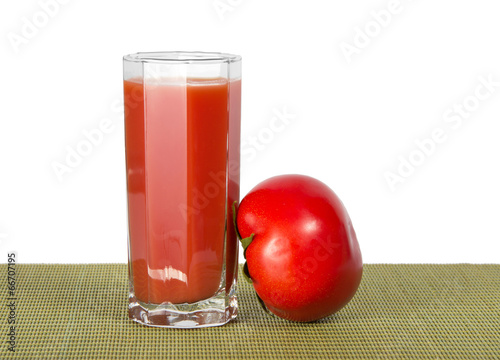 Glass of juice and tomato on the bamboo cloth