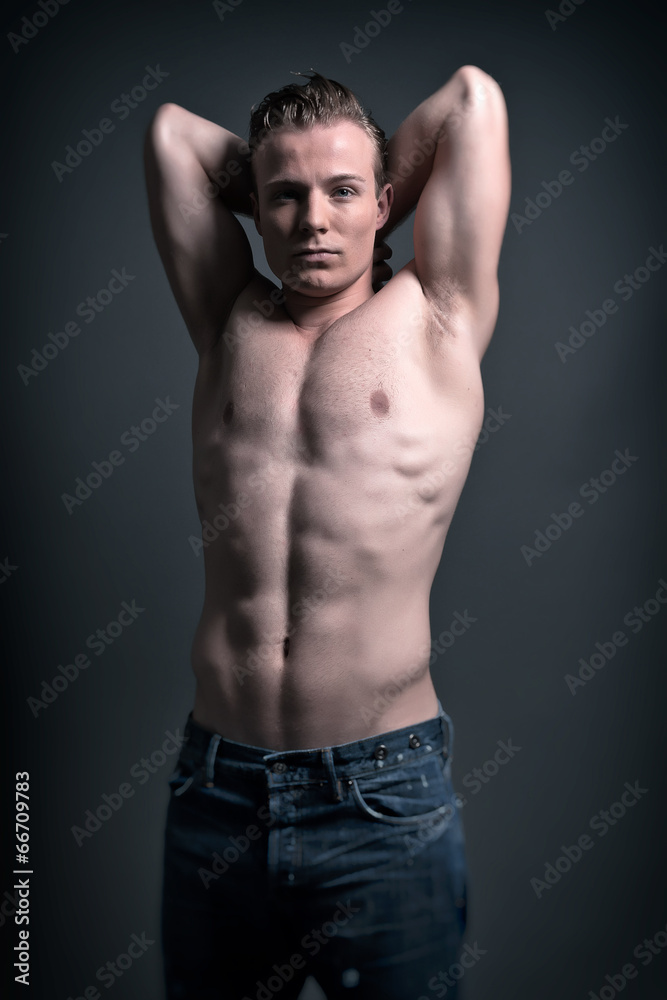 Healthy good looking young muscled fitness man wearing blue jean