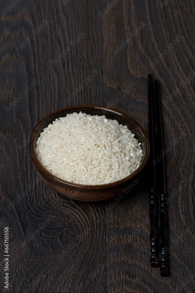 white rice in a bowl and chopsticks on dark background white rice in a bowl and chopsticks on dark background