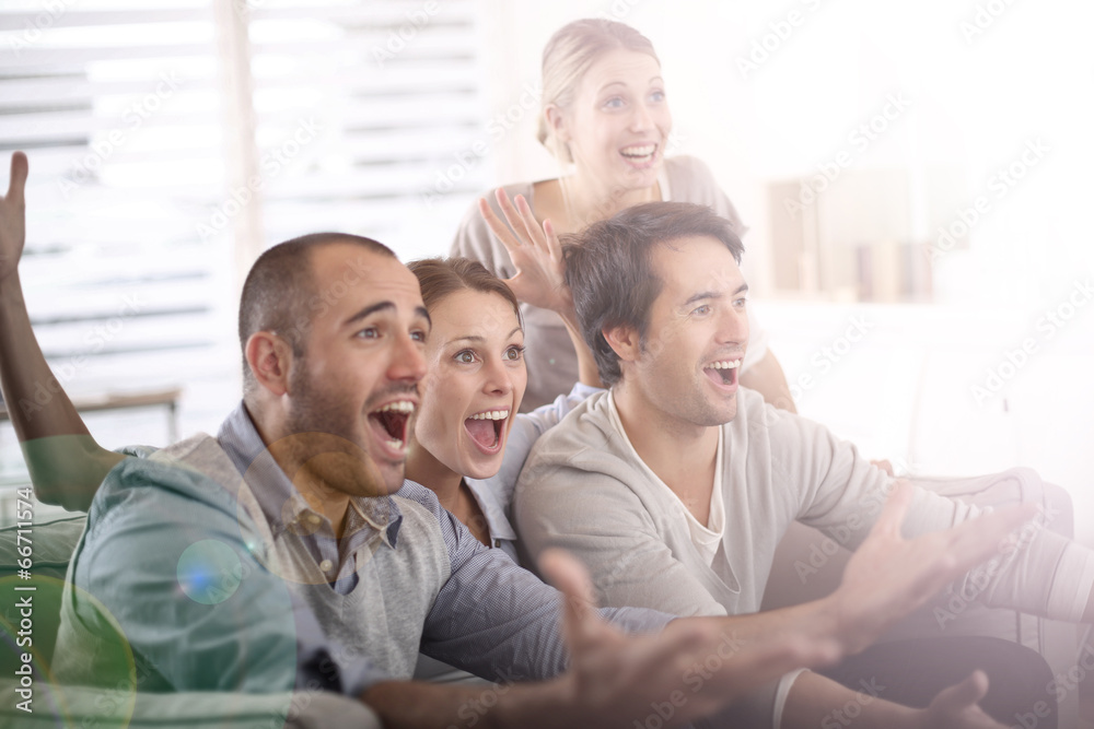 Cheerful group of friends watching football game on tv Cheerful group of friends watching football game on tv