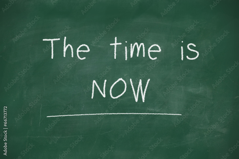 The time is now handwritten on blackboard The time is now handwritten on blackboard