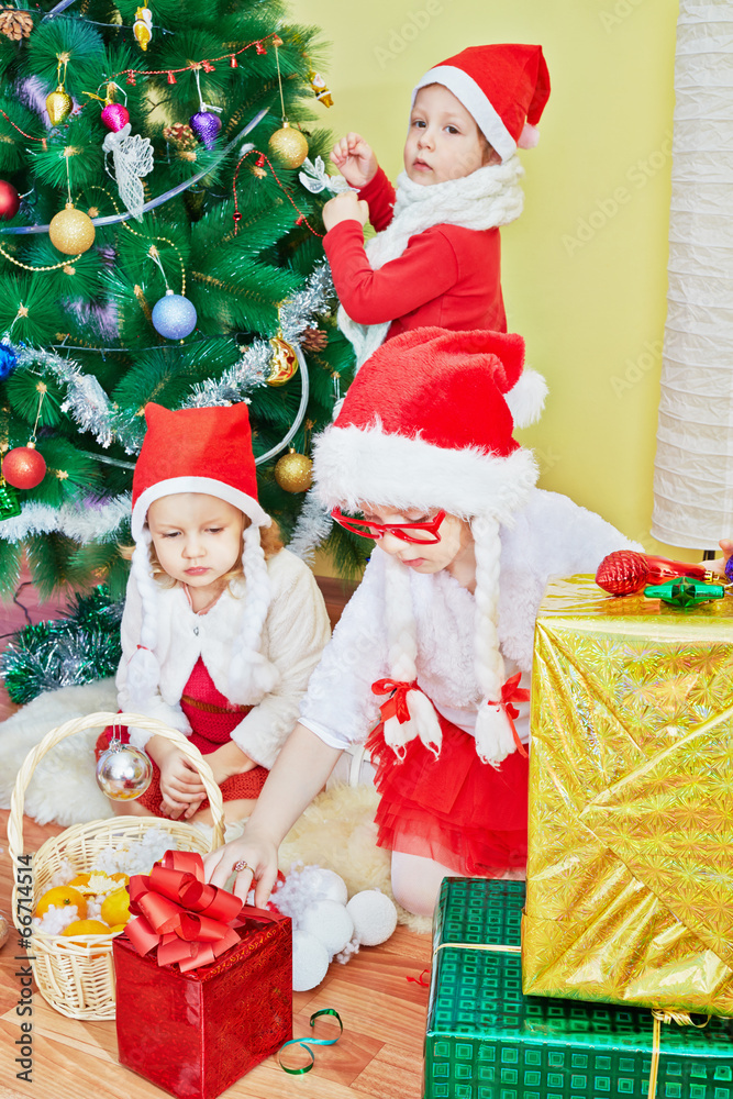 Two little girls in santa caps with strings