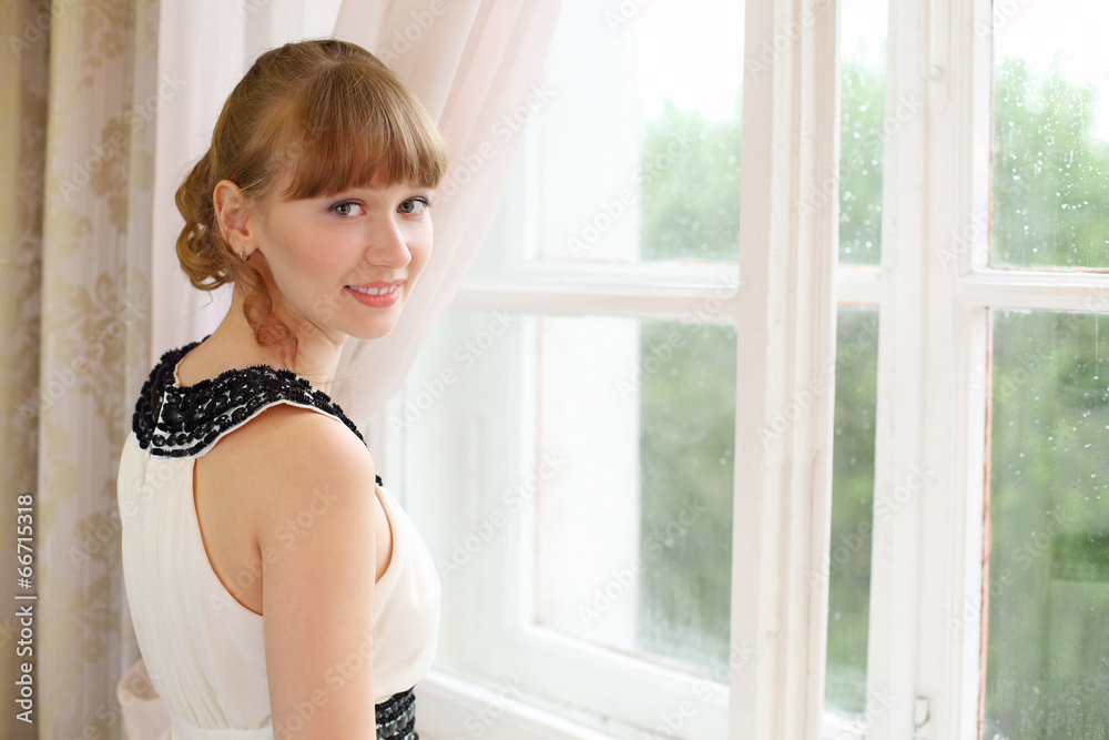 Beautiful smiling girl in white dress near window Beautiful smiling girl in white dress near window