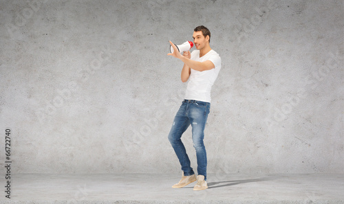 handsome man with megaphone over concrete wall