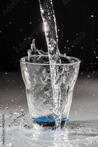 Versamento acqua nel bicchiere in  trasparenza photo