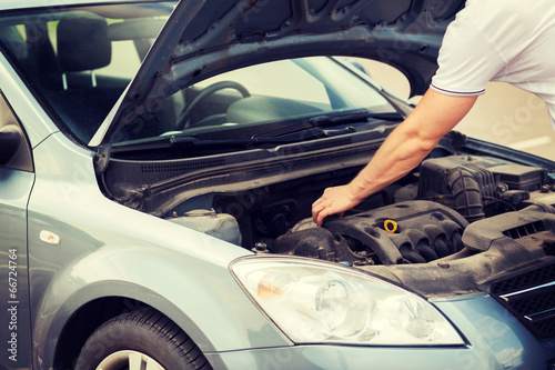 man opening car bonnet photo