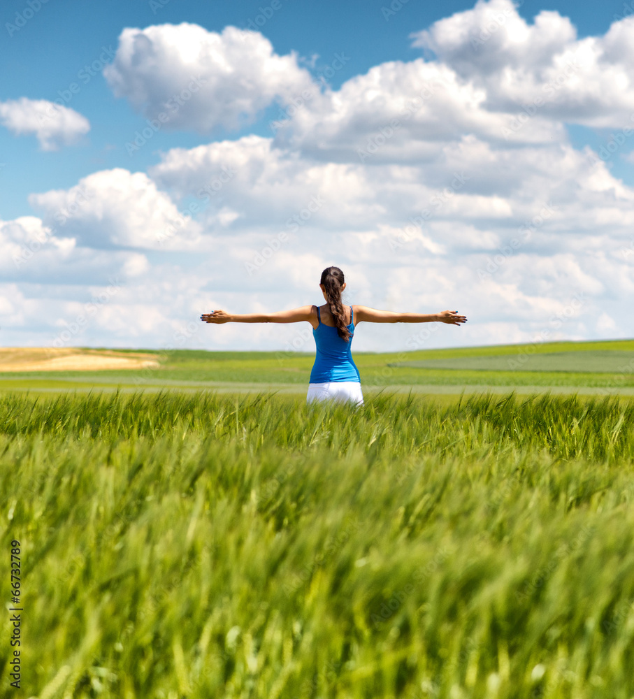 Image of a girl in a wheat field with spread arms Image of a girl in a wheat field with spread arms