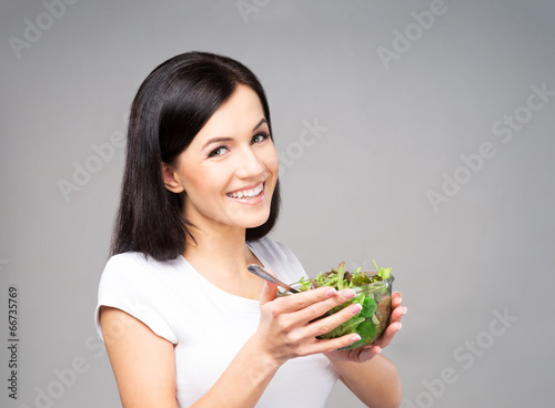 Young, beautiful and healthy teenage girl with a bowl of salad