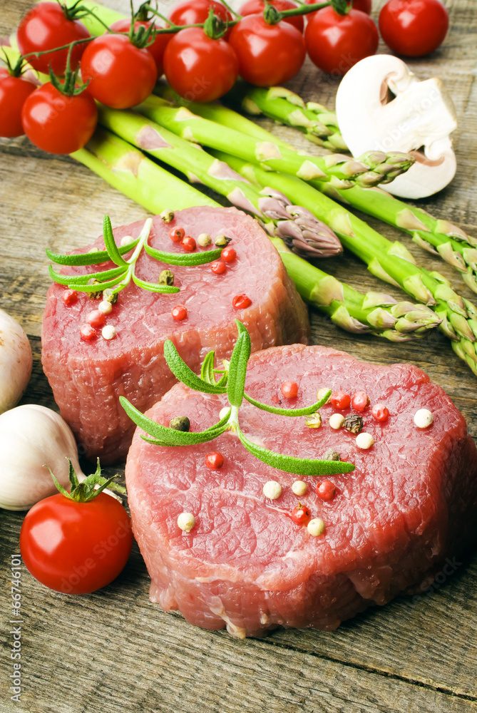 Raw Steak with green asparagus on wooden board Raw Steak with green asparagus on wooden board