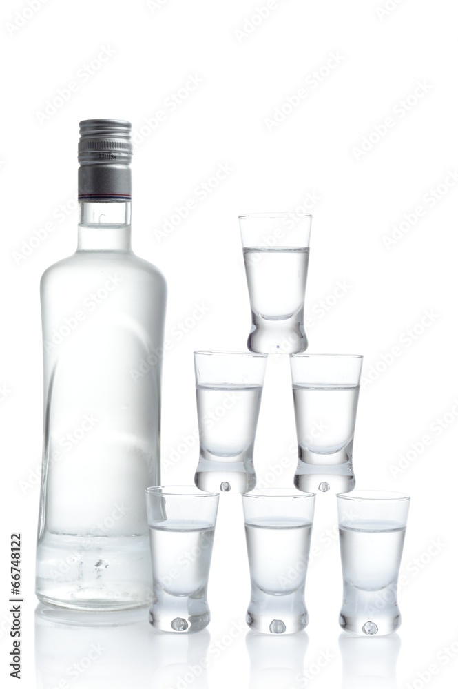 Bottle with many glasses of vodka isolated on white background Bottle with many glasses of vodka isolated on white background