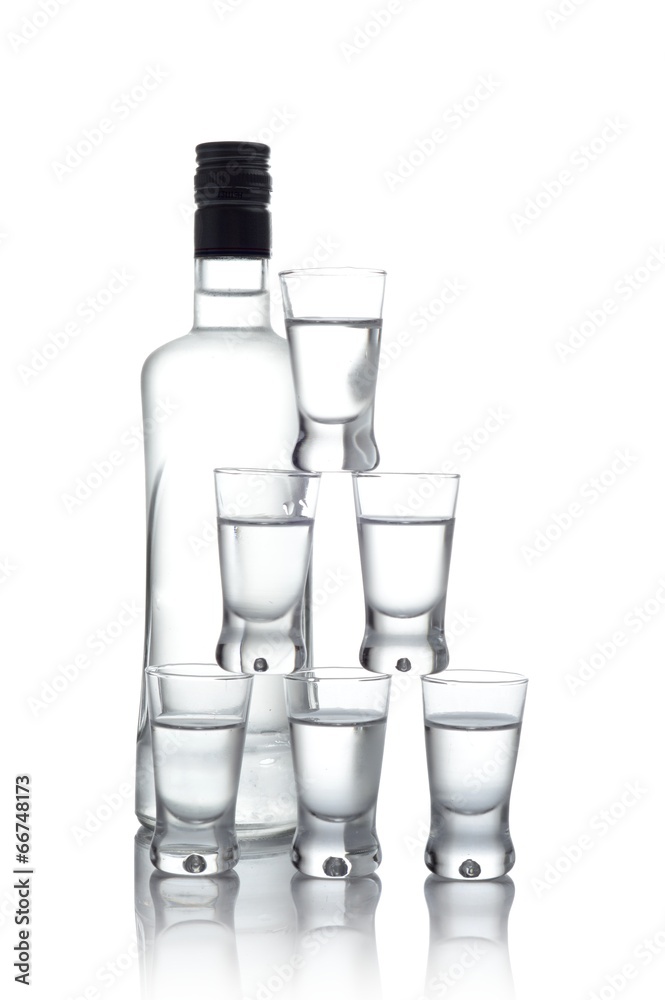 Bottle with many glasses of vodka isolated on white background Bottle with many glasses of vodka isolated on white background
