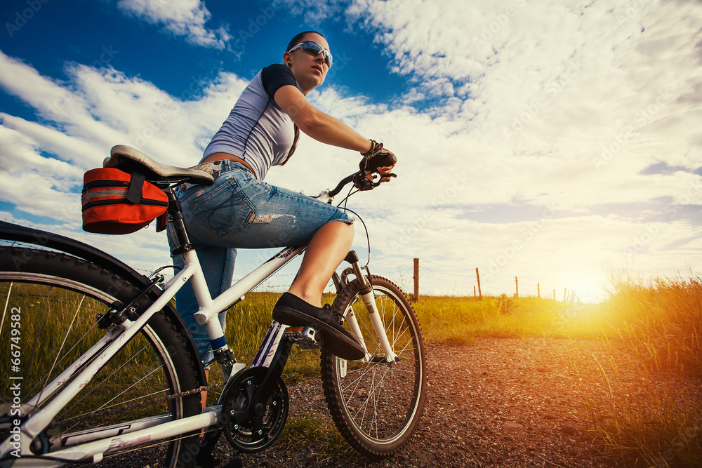 Woman is riding bicycle outside in the field Woman is riding bicycle outside in the field