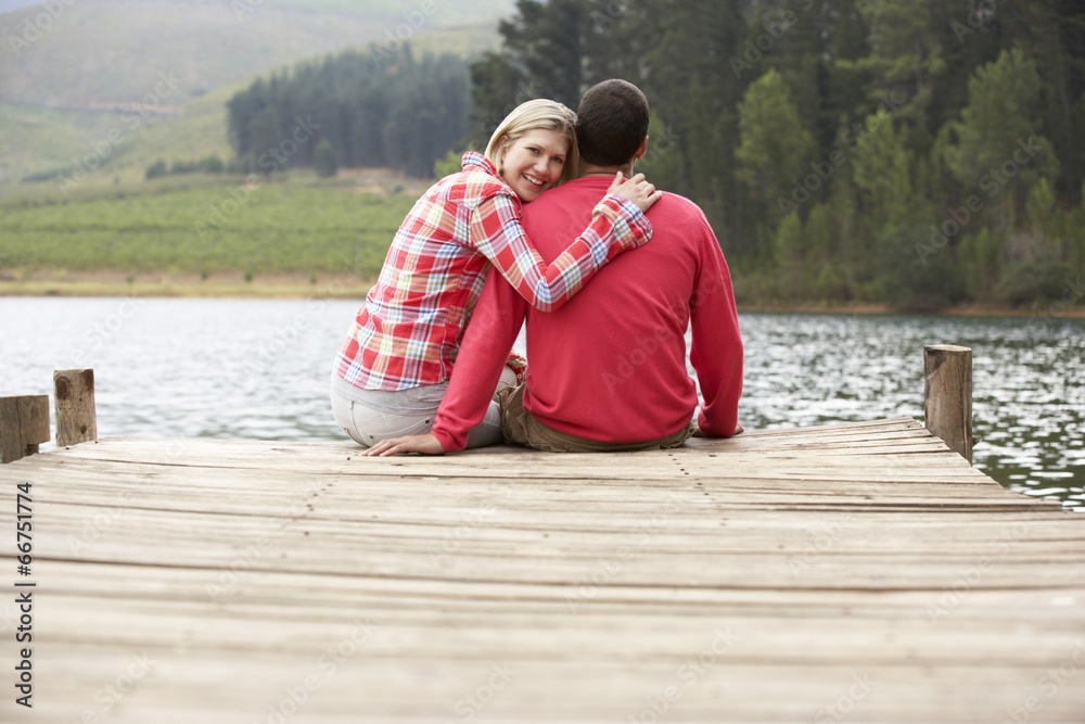Fototapeta premium Romantic couple sitting on a jetty