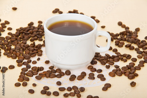 Cup with coffee, coffee grains, a napkin