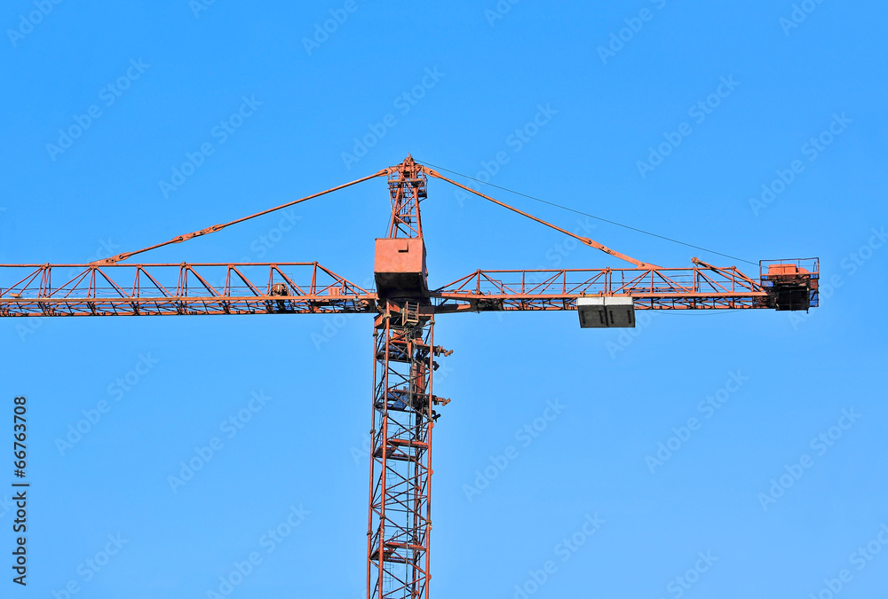 Red construction tower crane against blue sky Red construction tower crane against blue sky