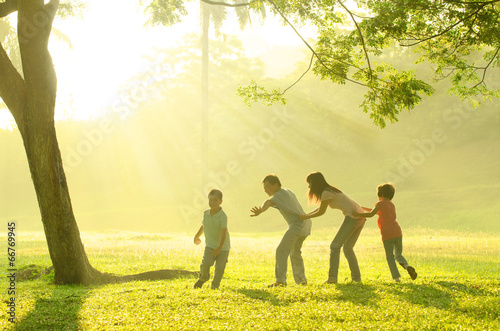 asian family playing with joy in park during a beautiful morning