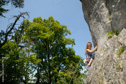 young woman climbing a rock wall
