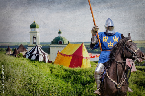Armored knight on warhorse over old medieval castle