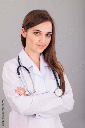 Young and beautiful nurse on a grey