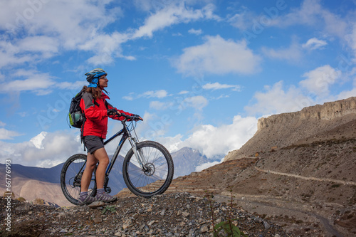 Girl cycling at the road in Himalaya